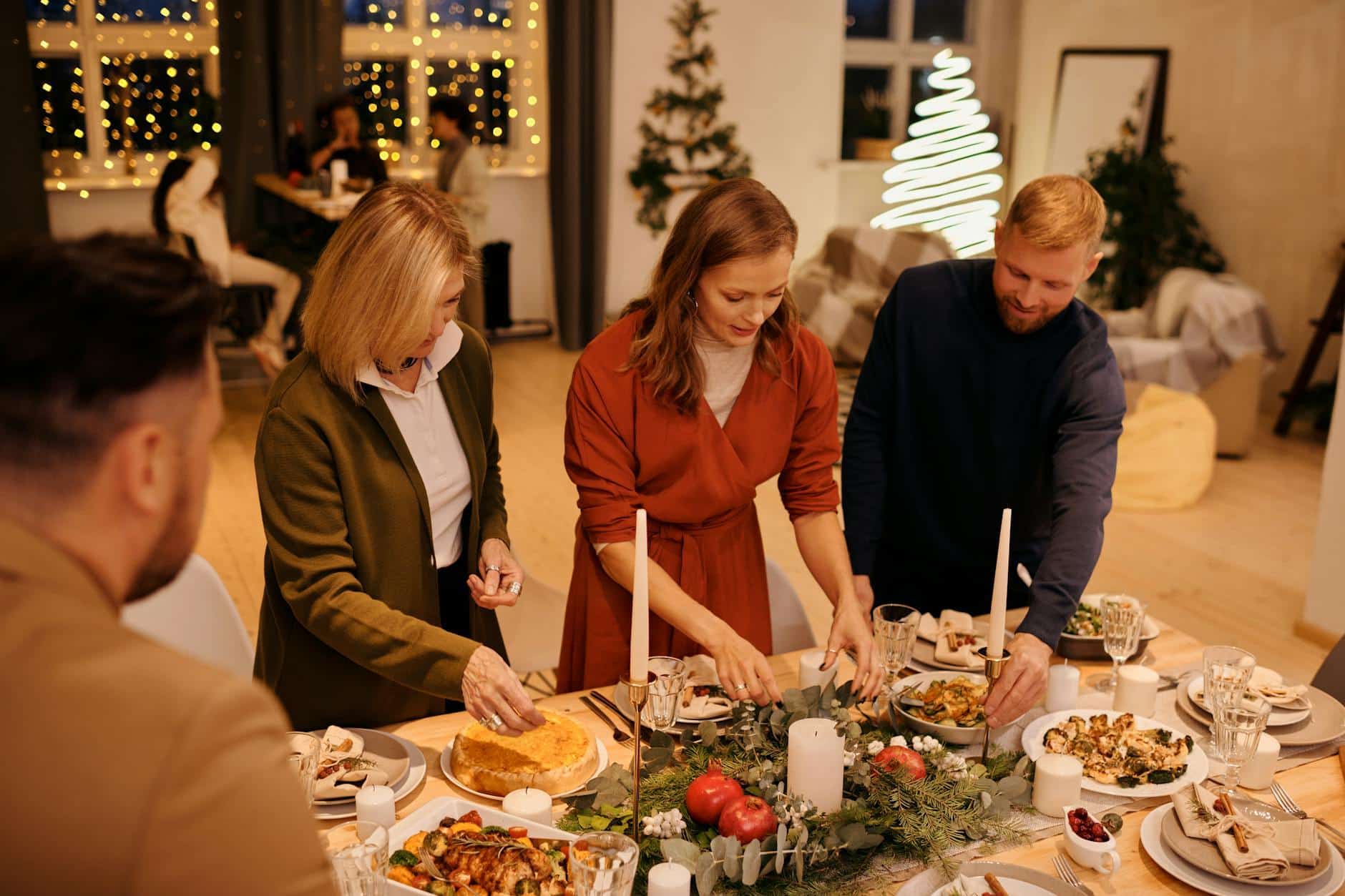 Table de fête décorée avec sapin illuminé et cadeaux en famille
