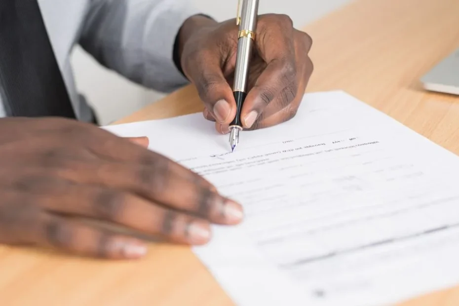Indépendant assis à son bureau, dossiers de santé ouverts, air perplexe